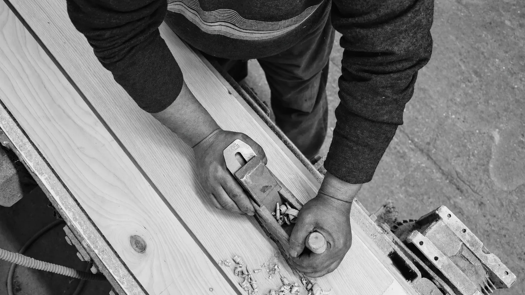 A carpenter planing a board